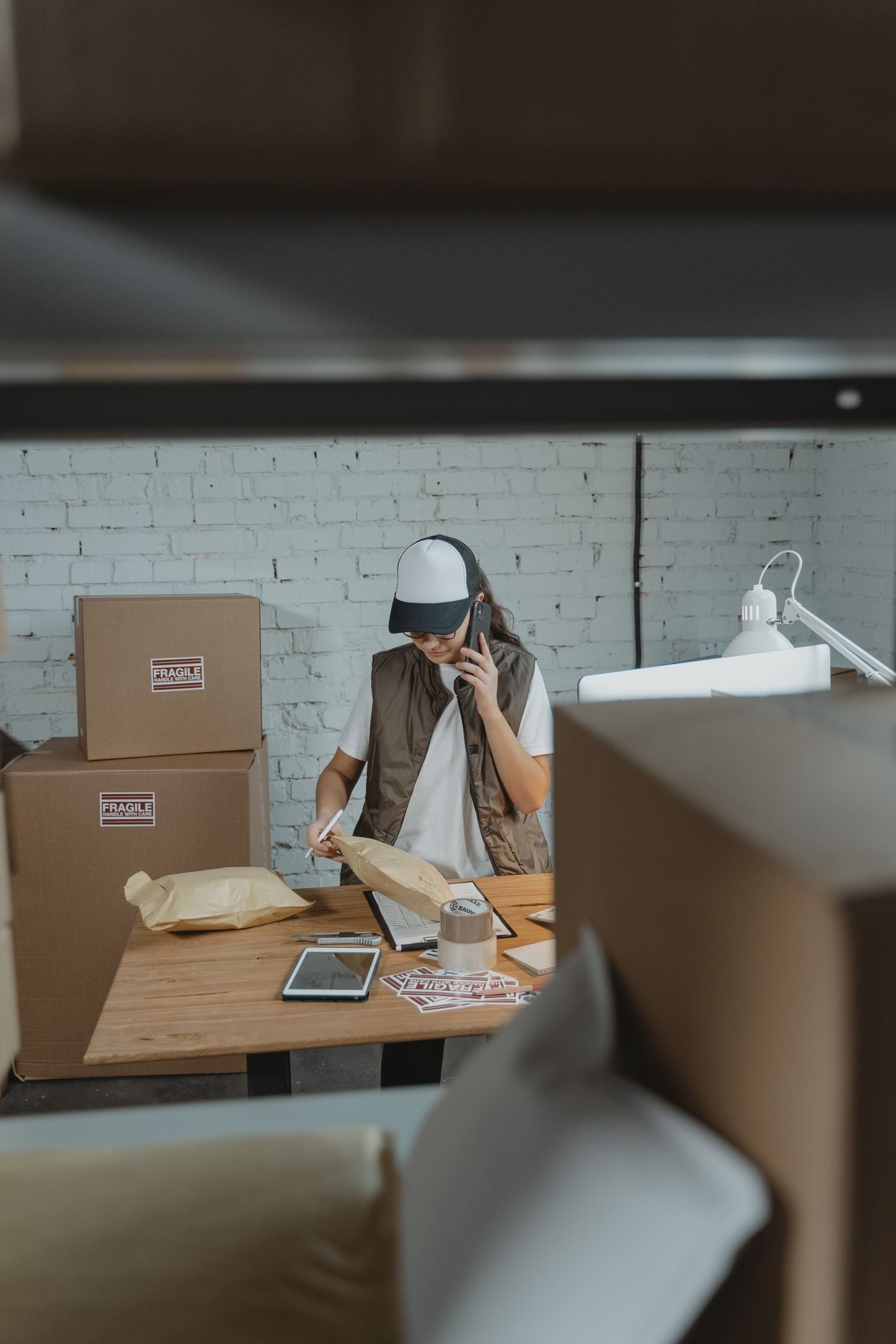 Reseller taking orders at her desk among packed parcels
