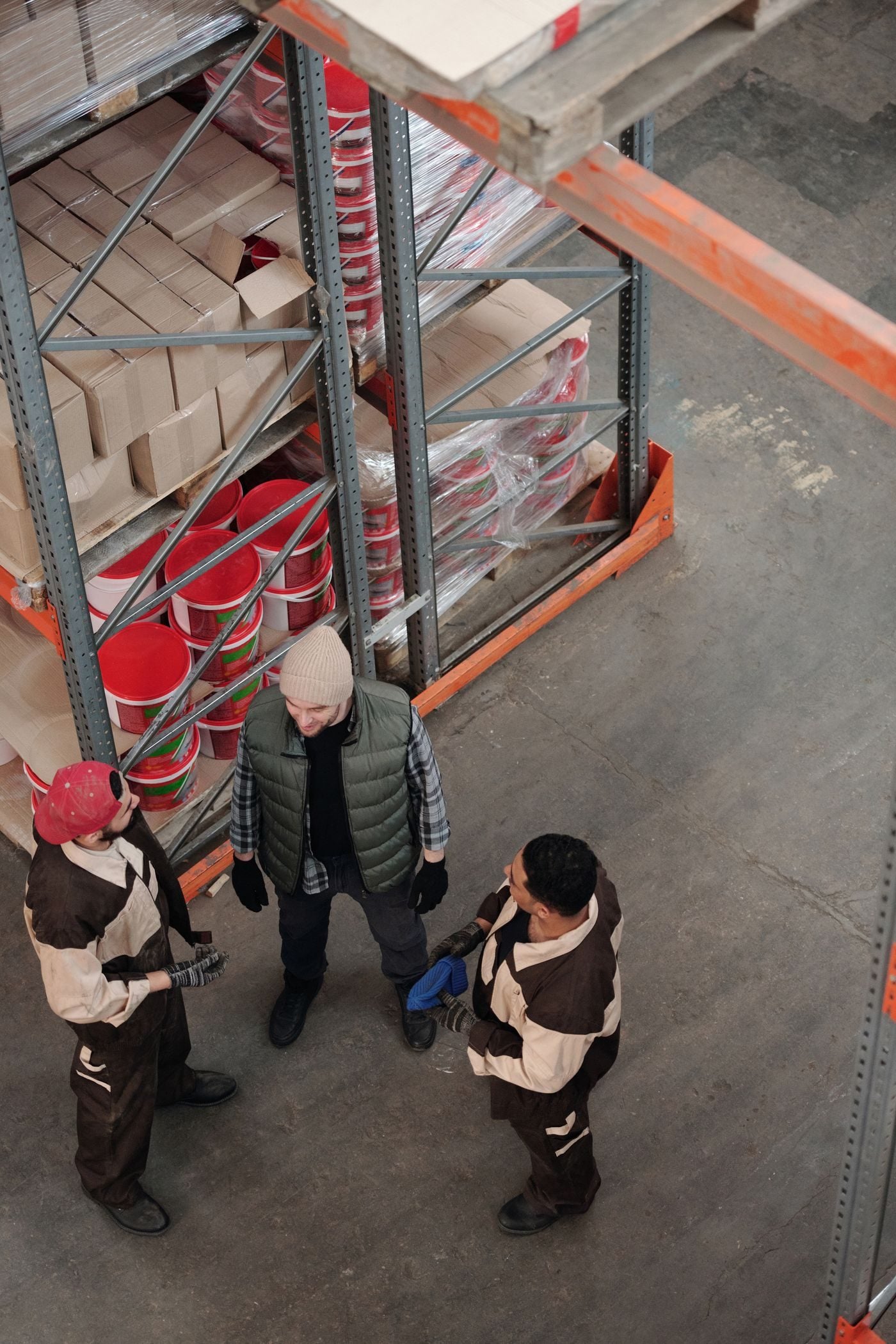 Warehouse team among racks and pallets, seen from above