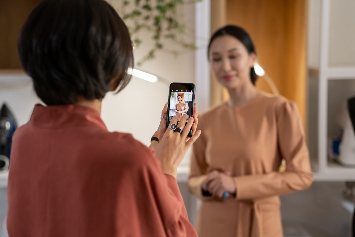 Reseller photographing an outfit on a phone to list it