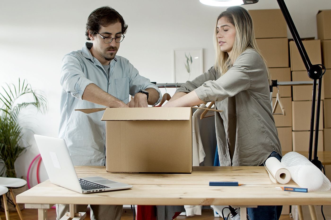 Two small-business owners unpacking a delivered wholesale lot in their studio