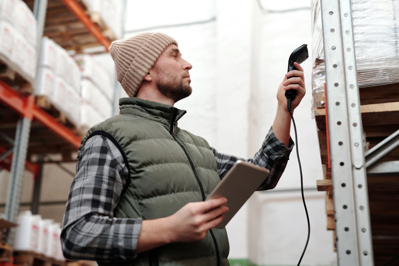 Warehouse owner scanning a carton with a phone and tablet to publish the lot
